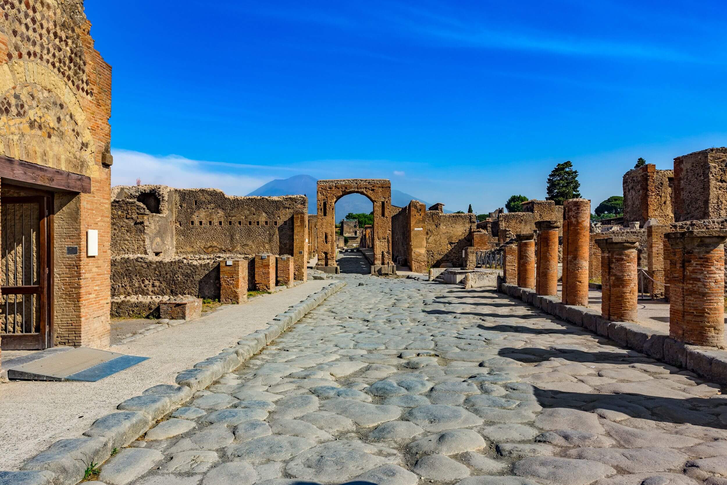 Polygonal basalt paving of the Via Appia stretching to the horizon between cypresses